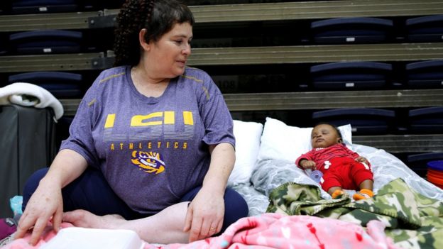 Louisiana evacuee Denise Vital, with her three-month-old godson, says her home was destroyed before, in 2005's Hurricane Rita