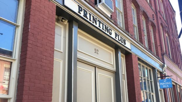 Fachada de un edificio con el cartel Printing Plus