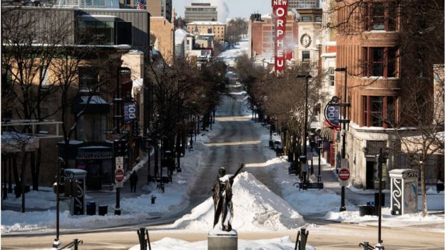 A sole individual walks down State Street in Madison, Wisconsin