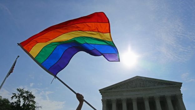 Gay pride flag flies in the sky next to the supreme court building in Washington DC in 2016.