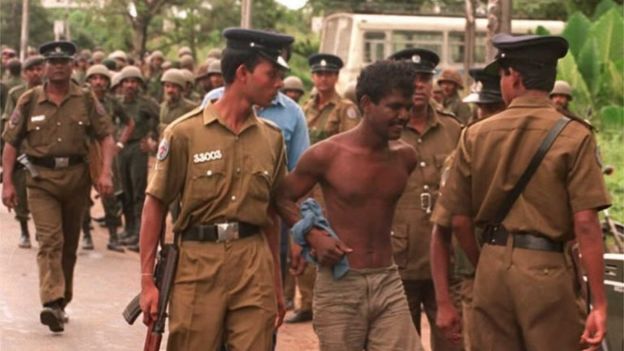Police take into custody a suspected Tamil Tiger guerrilla during a search operation near the Orugodawatte crude oil complex and the nearby Kolonnawa oil tank farm, which were allegedly blown up by suspected Tamil Tiger guerrillas in Colombo 20 October.