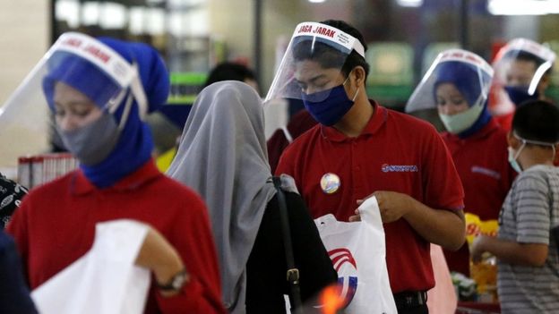 Petugas kasir salah satu pusat perbelanjaan memakai pelindung wajah dan masker saat melayani konsumen di Banda Aceh, Aceh. Pemakaian face shield dan masker oleh para pekerja sebagai upaya mengantisipasi penyebaran dan penularan virus corona.