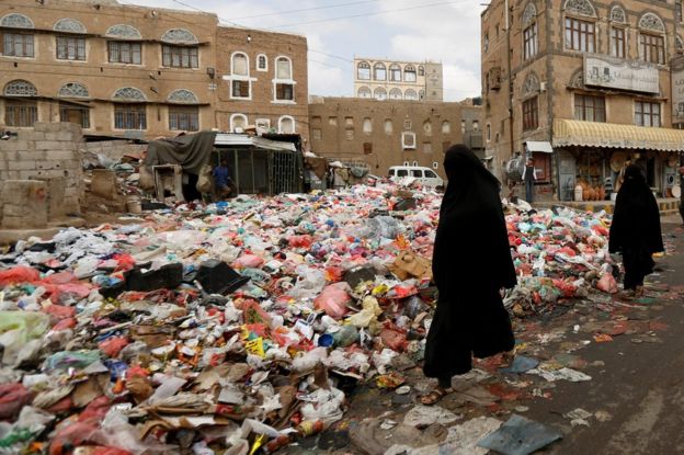 Mujeres caminan entre la basura acumulada en una calle de Saná, Yemen, el 8 de mayo de 2017.