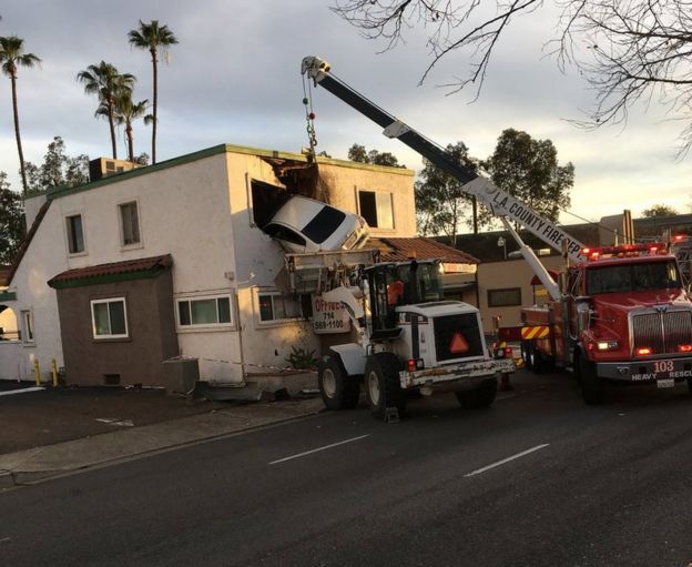 Rescue workers remove a car that crashed into a building after speeding into a median and going airborne, according to local media, in Santa Ana, California, U.S., January 14, 2018,