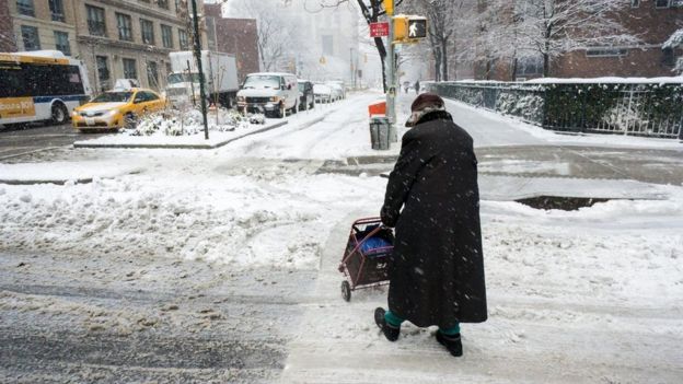 karda yürüyen yaşlı bir adam