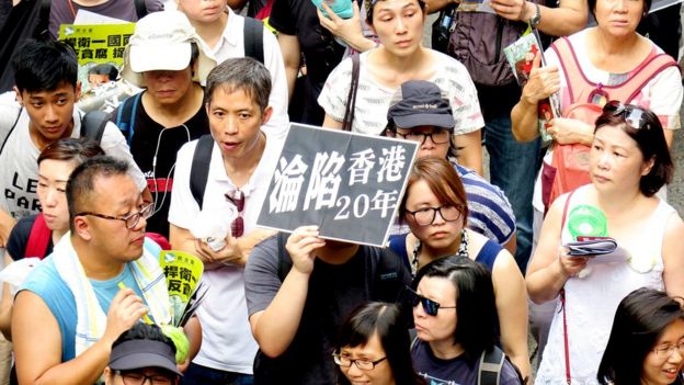 香港七一游行队列中一名示威者举起“香港沦陷20年”标语牌(1/7/2017)