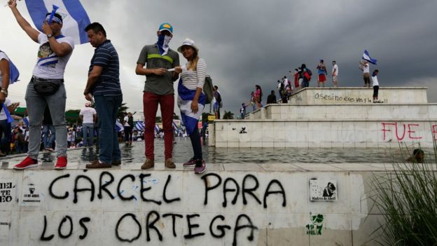 Demonstrators stand above graffiti reading "Jail for the Ortegas" in Managua on May 26, 2018