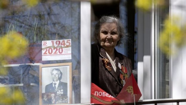 A woman displays a photo of a loved one in her window in St Petersburg, Russia