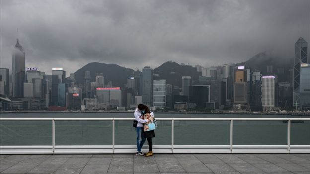 A couple stand on the observation desk at Tsim Sha Tsui in Hong Kong on February 14, 2020