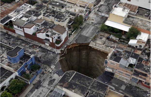 A sinkhole covers a street intersection in downtown Guatemala City