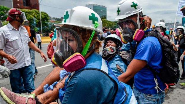 Rescatistas ayudan a un herido de las protestas.