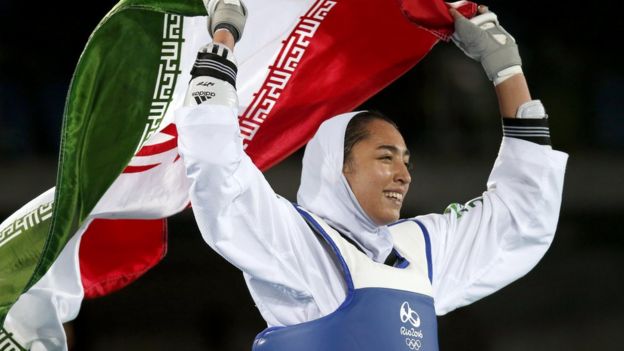 Kimia Alizadeh of Iran celebrates with the national flag after winning the women's -57kg bronze medal bout of the Rio 2016 Olympic Games Taekwondo event