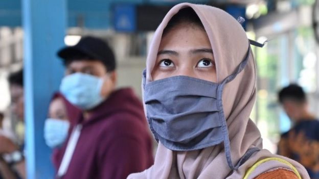 Seorang warga Jakarta mengenakan masker.