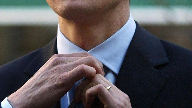 Man adjusts his tie
