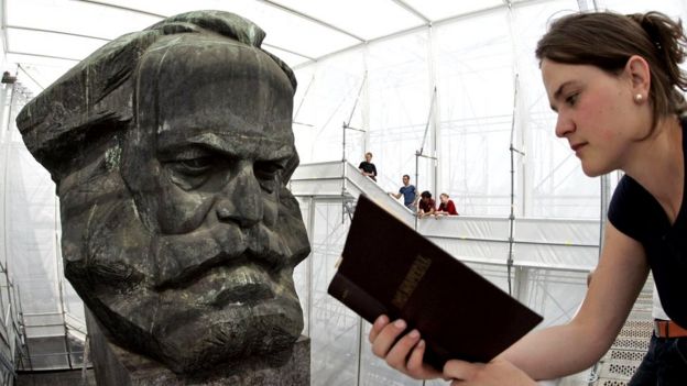 Jovem lee 'O Capital' em frente ao busto de Marx
