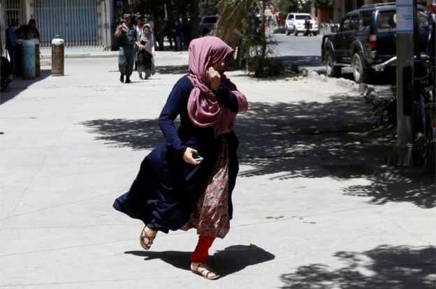 An Afghan women runs away during gun fire at the site of an attack in Kabul, Afghanistan 31 July 2017.