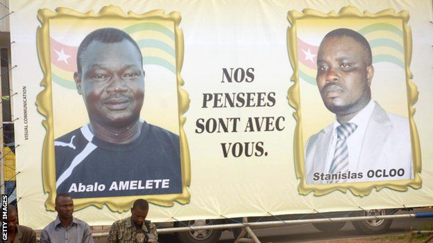 Un panneau d'affichage rend hommage à deux des victimes - l'entraîneur adjoint Pascal Amalete Abalo Dosseh et le responsable des médias Stanislas Ocloo