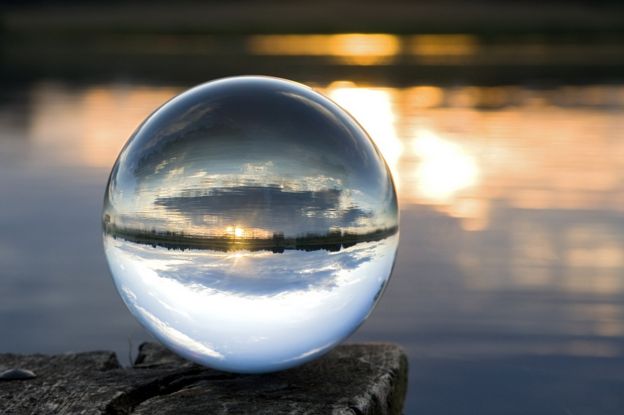 a crystal ball by a lake at sunset