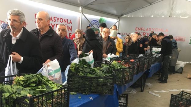 Istanbul residents queue along the vegetable stalls to buy produce