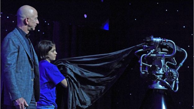 A child from Blue Origin's "Club for the Future" helps Jeff Bezos unveil the BE-7 rocket engine