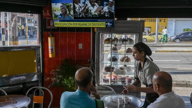 Clientes de un café de Medellín ven la noticia del rearme de Iván Márquez.