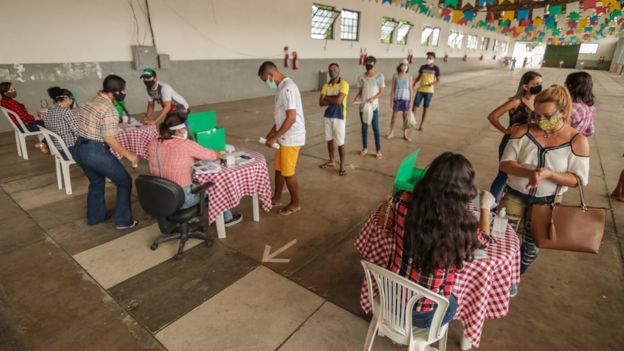 Pessoas se inscrevendo para receber cesta básica de doação