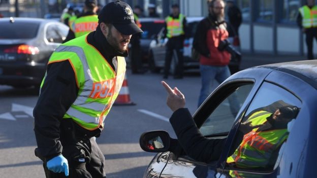 شرطي ألماني يتحدث مع شخص على الحدود الفرنسية الألمانية