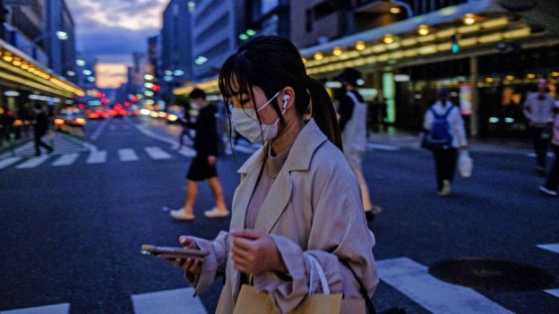 Mujer en las calles de Kioto con una máscara protectora