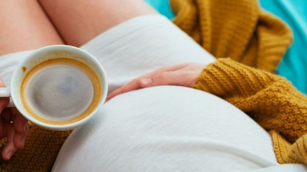 Une femme enceinte avec une tasse de café