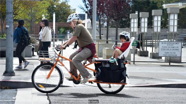 Pai anda de bicicleta com filho