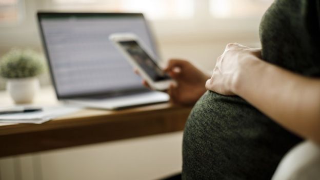 mujer embarazada usando celular