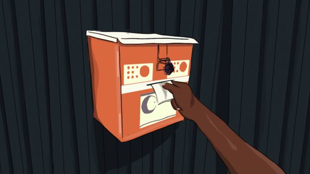 A hand slips a note into the "talking box"