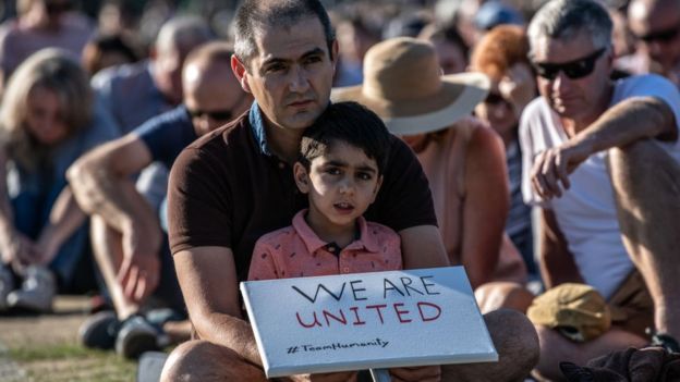 A young boy holds a placard as he takes part in a vigil to remember the victims of the Christchurch mosque attacks, on March 24