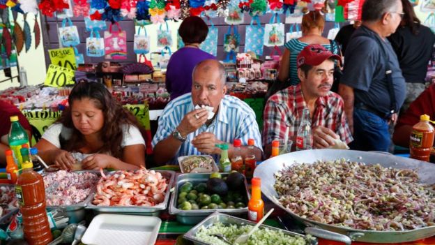 Mexicanos comiendo en un mercado de Guadalajara