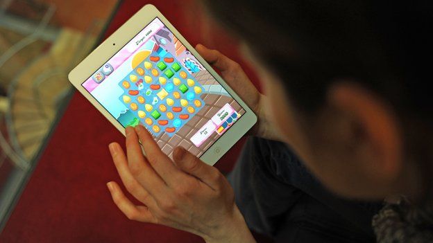 Woman plays Candy Crush Saga on iPad