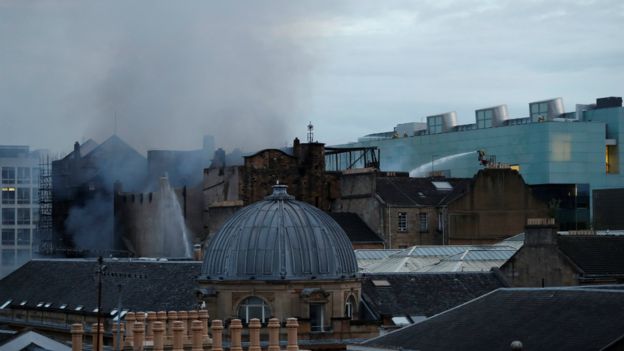 Firefighters continue to battle the fire as dawn breaks over Glasgow