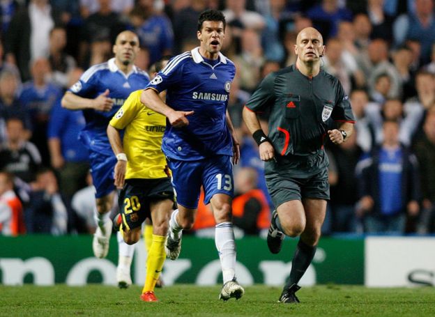 El árbitro noruego Tom Ovrebo es perseguido por el alemán Michael Ballack en Stamford Bridge.