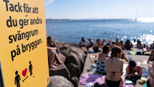 Heatwave in Malmo: An information sign ask people to keep social distance due to the corona pandemic