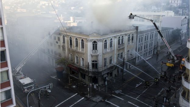 Bomberos tratan de apagar un incendio en una farmacia de Valparaíso.