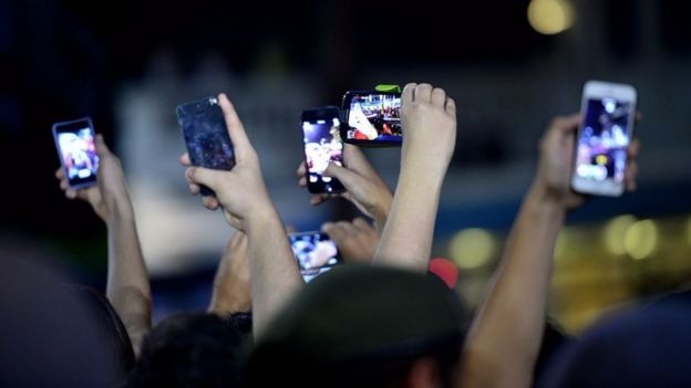 Manos sosteniendo teléfonos celulares