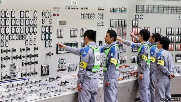 Operators check monitors of the nuclear reactor in the central control room of the Kyushu Electric Power Sendai nuclear power plant on August 14, 2015.