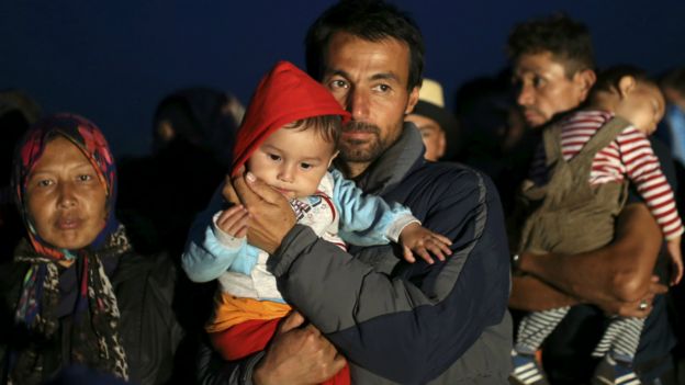 Migrants wait foar a bus at a migrant collection point in Roszke, Hungary - 12 September 2015