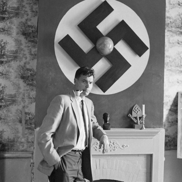 Rockwell en su casa con una bandera nazi en el fondo