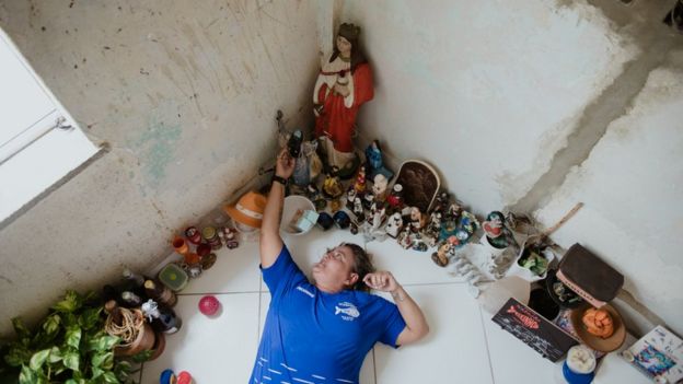 Peixinho ao lado de altar sincrético com orixás e santos católicos