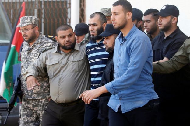 Members of Palestinian security forces loyal to Hamas escort a prisoner in Gaza City, 21 May