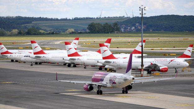 A plane of the low-cost airline Wizz Air (foreground) prepares to take off from the Schwechat airport near Vienna, Austria, on May 1, 2020