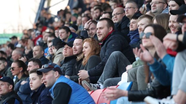 Fans cheer, as they are watching the Belarusian Premier League soccer match between FC Minsk and FC Dinamo-Minsk in Minsk on 28 March