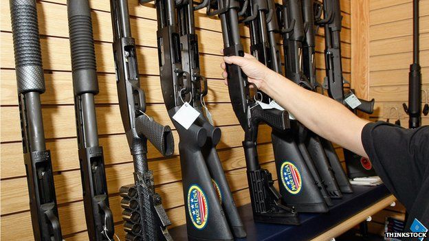 Мужчина берет пистолет с витрины дробовиков в оружейном магазине в Лас-Вегасе
