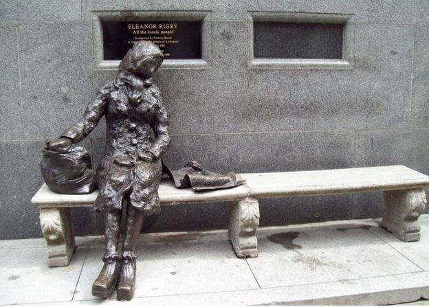 Escultura de Eleanor Rigby em bronze, sentada em um banco de pedra