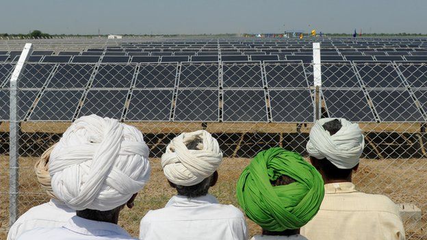farmers looking at a solar panel in India
